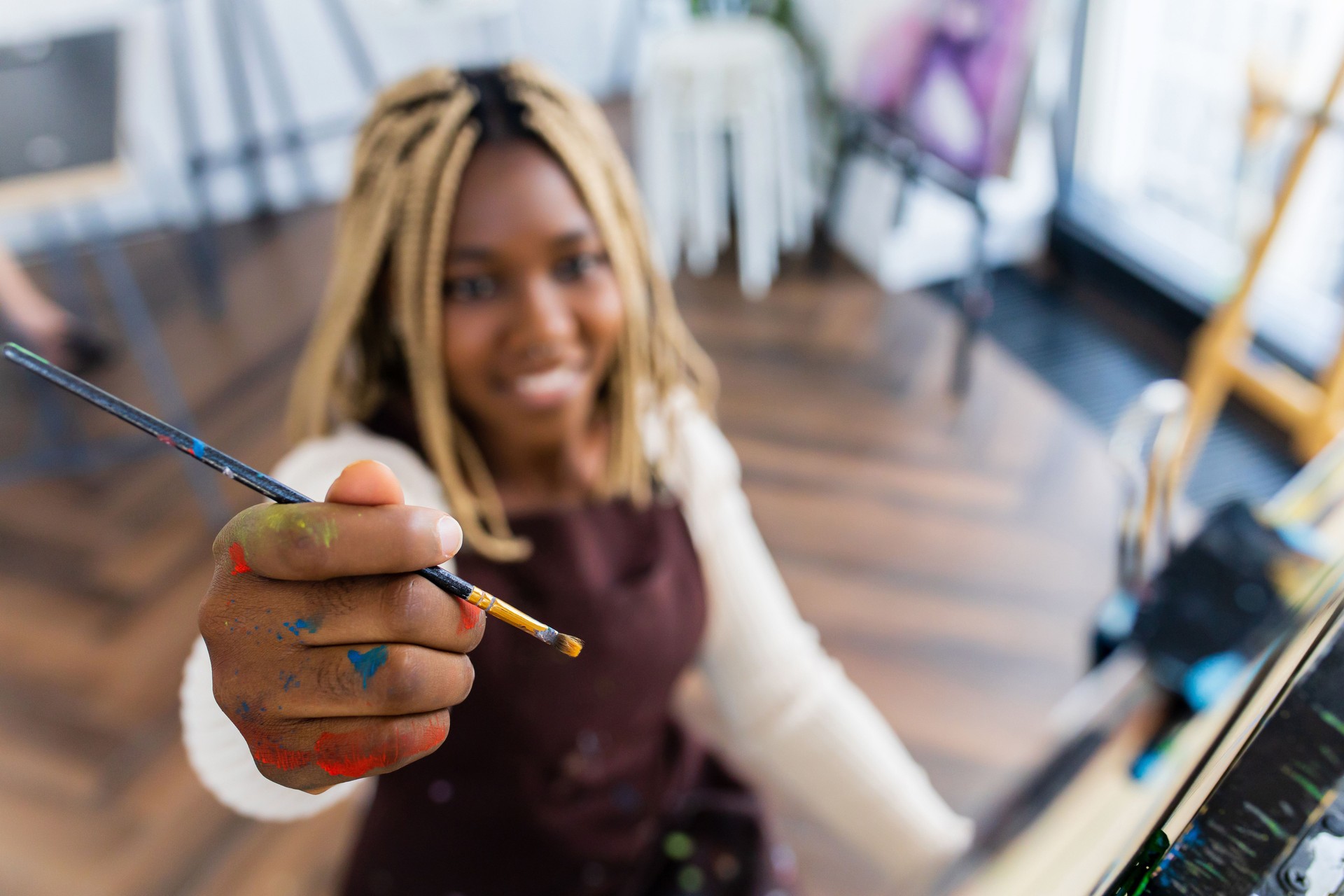 african american woman student in art class inspired and painting