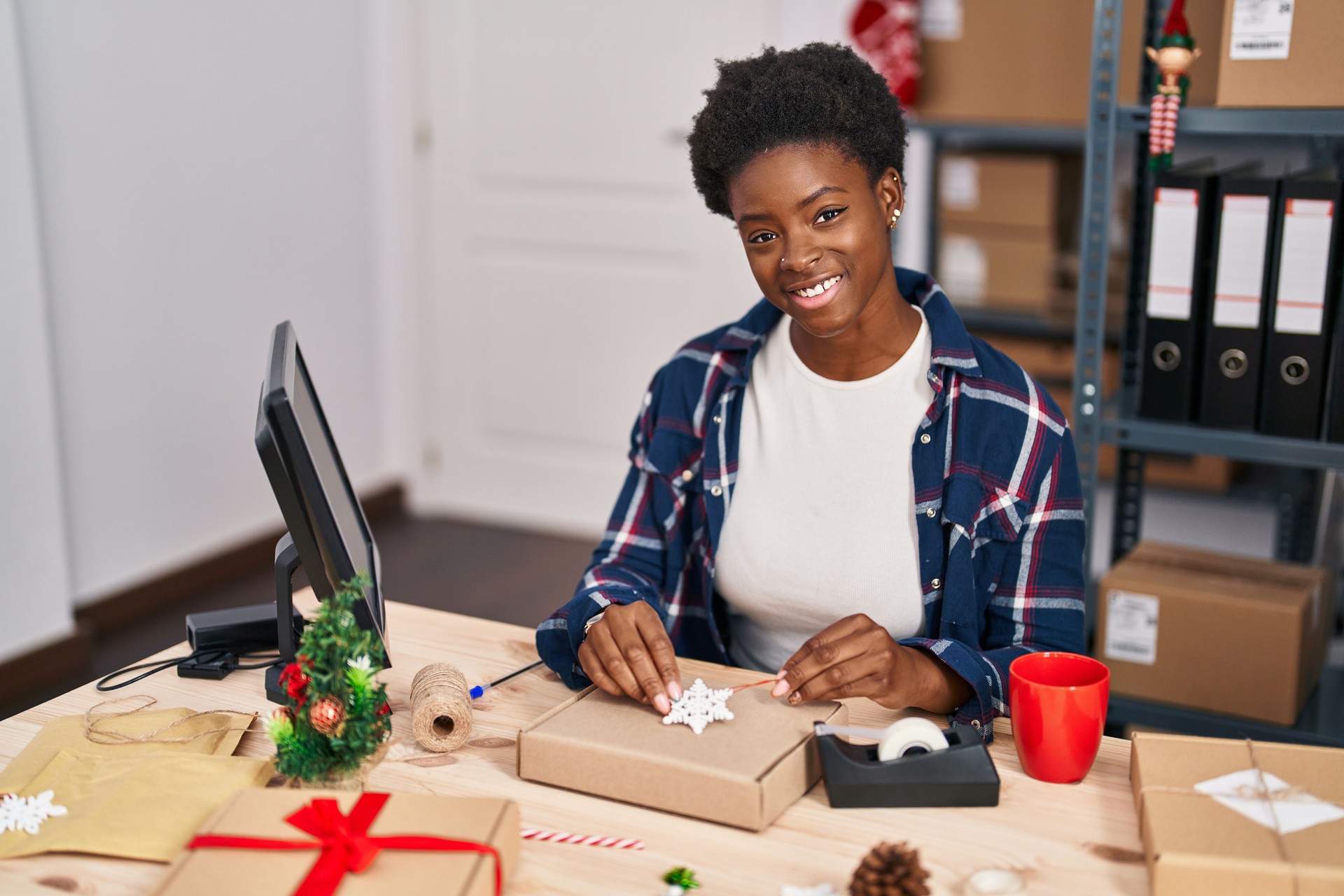 African american woman ecommerce business worker preparing gift at office